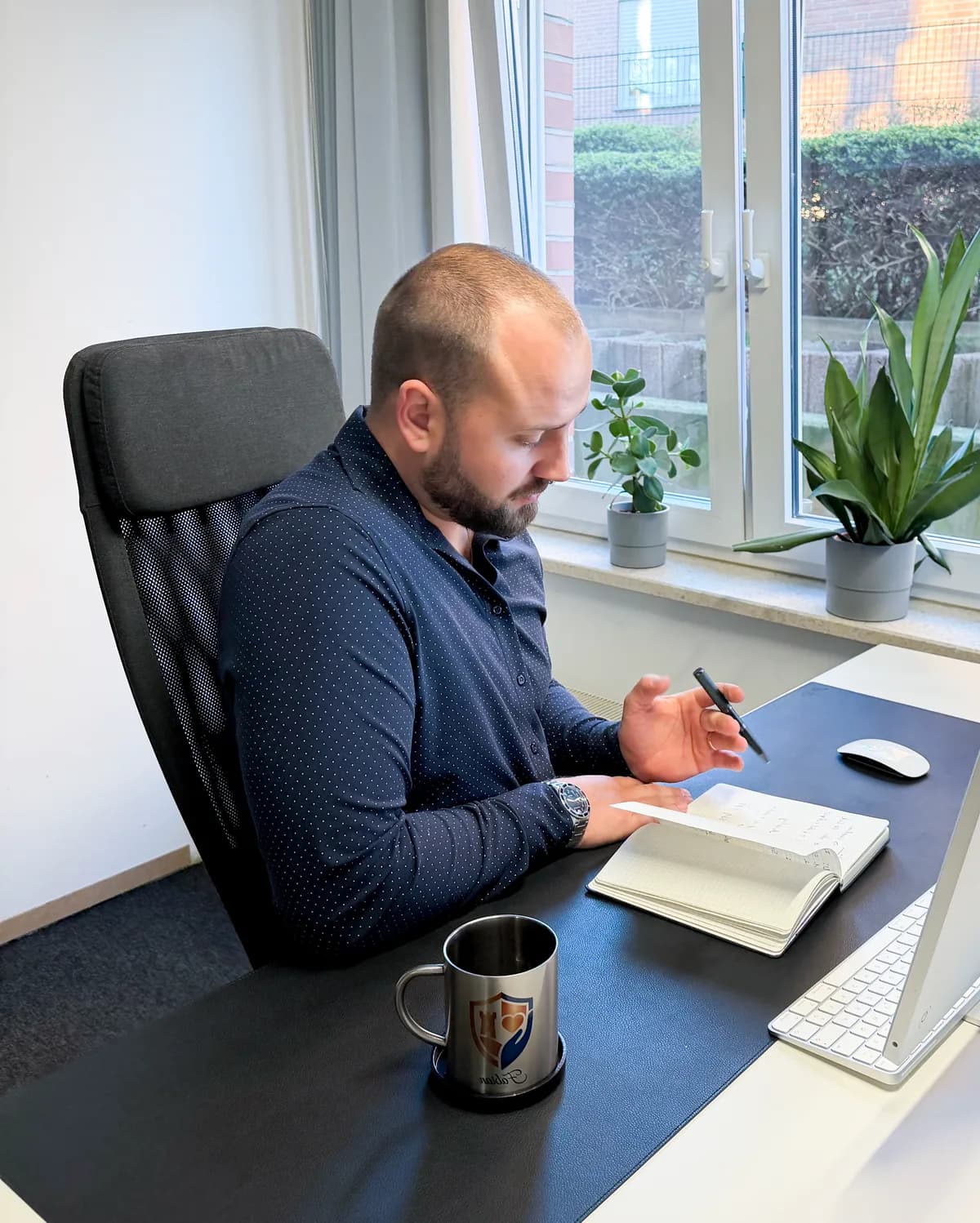 Fabian Bröggelhoff notiert Zahlen in einem aufgeschlagenen Notizbuch an seinem Schreibtisch